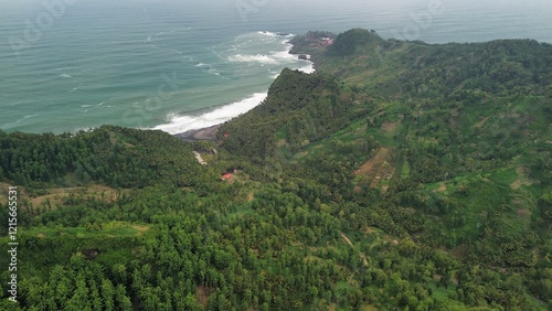 Drone view of Embung Srati or Embung Silayur Kebumen, a large water reservoir on green hills with forests and trees and rows of hills around it. photo