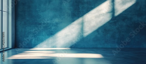 Blue textured wall with sunlight rays casting shadows on a clean floor and ample Copy Space for text placement