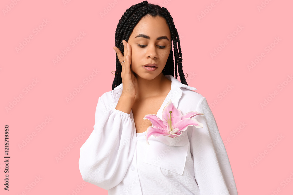 Beautiful young African-American woman with lily flower on pink background Beautiful young African-American woman with lily flower on pink background