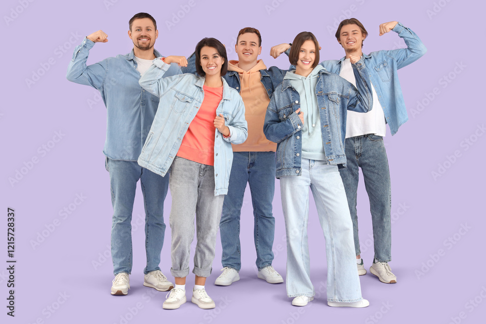 Group of young people in denim clothes showing muscles on lilac background Group of young people in denim clothes showing muscles on lilac background