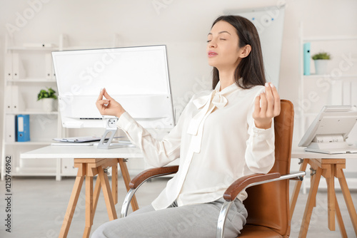 Young businesswoman meditat...
