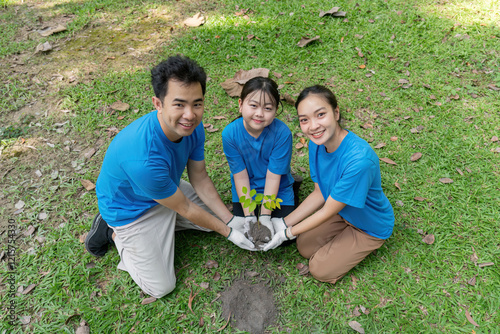 Family volunteers planting trees together to promote environmental conservation and save the world photo