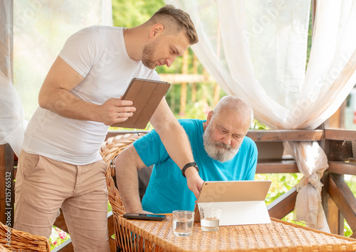 senior man pensioner using tablet photo