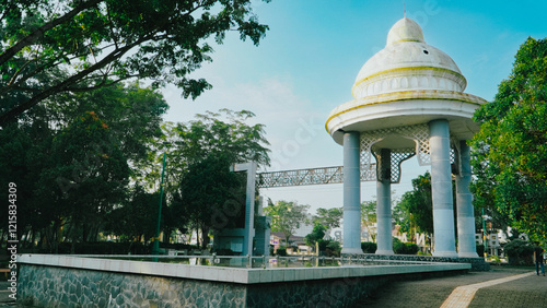 Fotografie White monument building with a distinct yellow dome in a park.