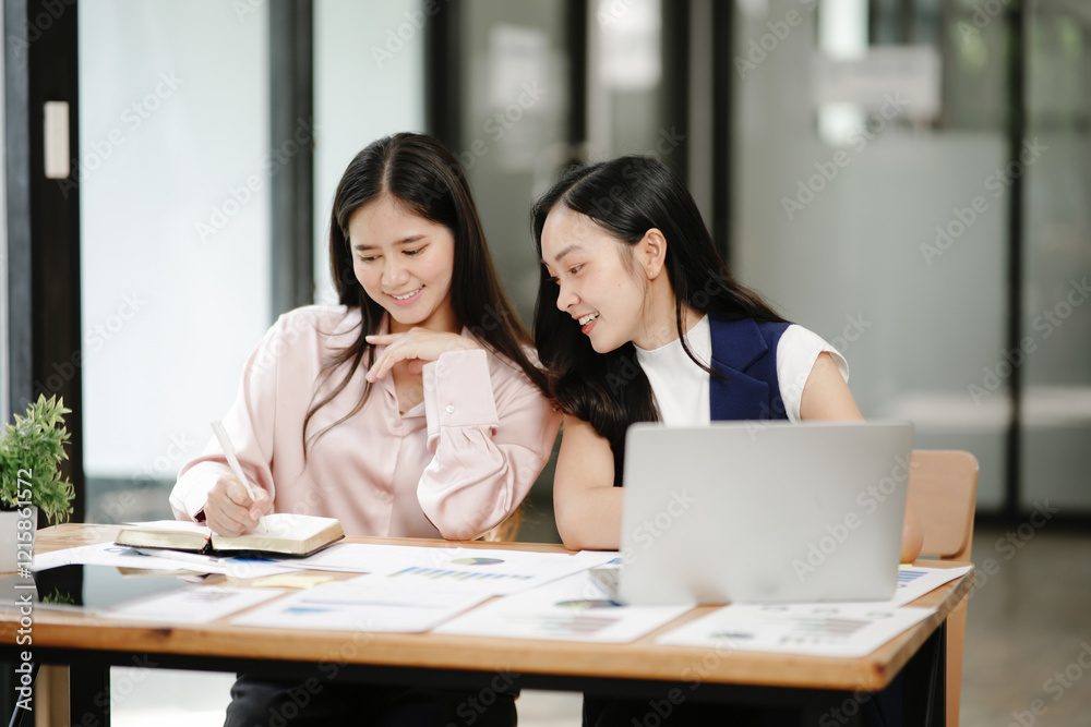 Two business women sitting and working Documents in front of the computer Two business women sitting and working Documents in front of the computer