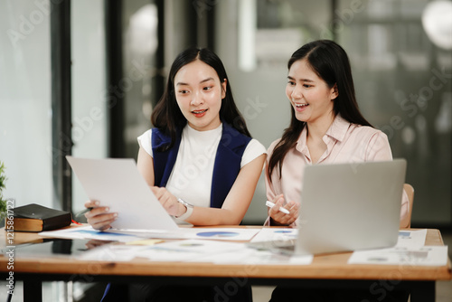 Two business women sitting and working Documents in front of the computer
