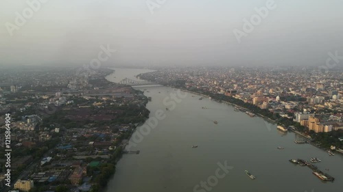 Aerial drone shot of Howrah Bridge spanning the Hooghly River, a landmark of Kolkata's rich heritage. photo