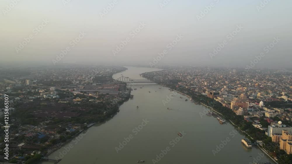 Stunning aerial view of the iconic Howrah Bridge over the serene waters of the Hooghly River in Kolkata.