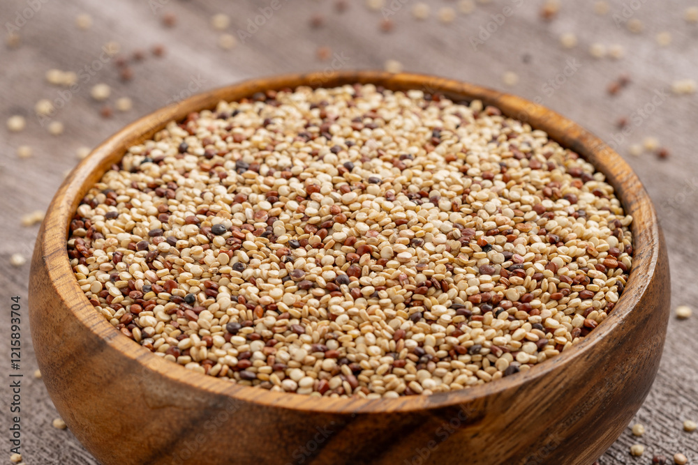 Wooden bowl filled with mixed quinoa grains, featuring white, red, and black seeds on a rustic wooden surface, ideal for healthy food and nutrition concepts. Wooden bowl filled with mixed quinoa grains, featuring white, red, and black seeds on a rustic wooden surface, ideal for healthy food and nutrition concepts.