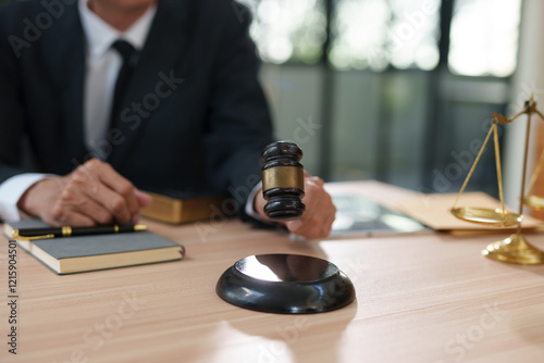 A focused, close-up shot of a black metal justice scale standing on a wooden desk, symbolizing law and equity.