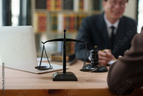 A focused, close-up shot of a black metal justice scale standing on a wooden desk, symbolizing law and equity.