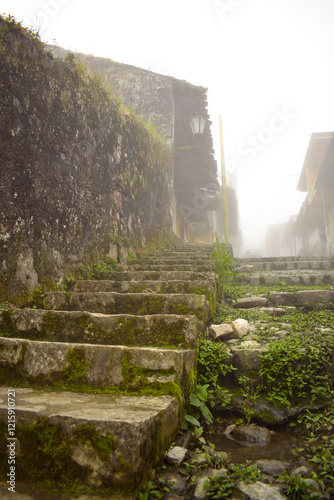 Fototapeta Naklejka Na Ścianę i Meble -  Cuetzalan streets full of moss, a small puddle of water, traditional architecture of the Cuetzalan region