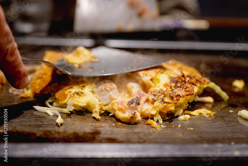 Okonomiyaki is one of Osaka’s famous foods.Teppanyaki is a Japanese cuisine that uses an iron griddle to cook food. photo