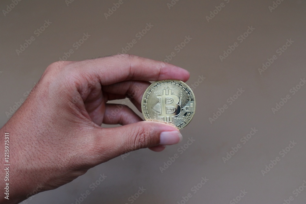 A man's hand holds bitcoin A man's hand holds bitcoin
