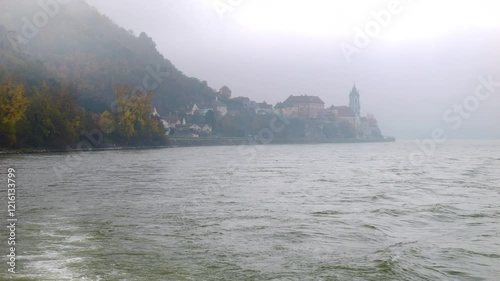 Moving on the foggy river Danube looking at Dürnstein in Austria in autumn