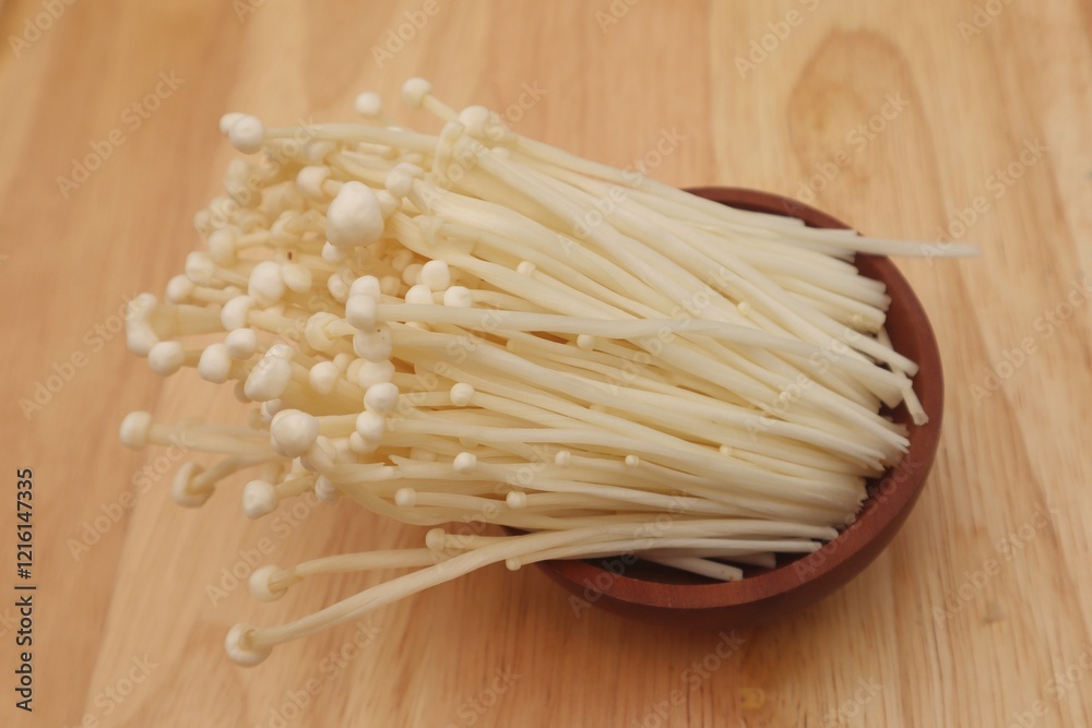 Enoki mushroom or Flammulina velutipes isolated on wooden background, close up view. Enoki mushroom or Flammulina velutipes isolated on wooden background, close up view.