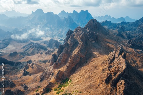 Aerial view of rugged mountain range, hazy valley, travel brochure