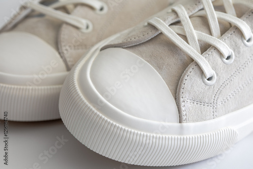 Closeup view of white beige suede rubber sneakers