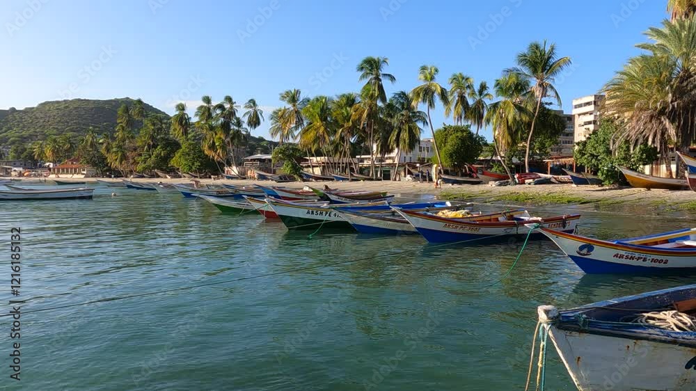 Experience a breathtaking late afternoon at Playa Pampatar, Isla Margarita, Venezuela. Fishing boats moored in a tropical bay at sunset amidst palm trees, ocean views, and vivid Caribbean colors. Experience a breathtaking late afternoon at Playa Pampatar, Isla Margarita, Venezuela. Fishing boats moored in a tropical bay at sunset amidst palm trees, ocean views, and vivid Caribbean colors.