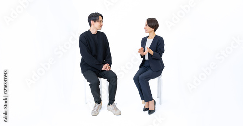 私服の男性と話すスーツを着た女性