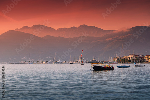 Obraz na płótnie Scenic view of Tivat cityscape and harbor in Montenegro, with the bay of Kotor and mountains in the background during a colorful sunset w salonie