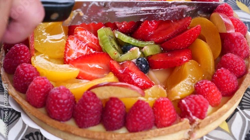 Person cuts a delicious fruit pie