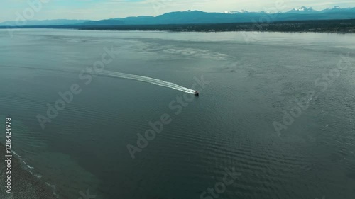 aerial shot over discovery passage between campbell river and quadra island revealing the mount washington in the background and a boat sailing, vancouver island, british columbia, canada photo