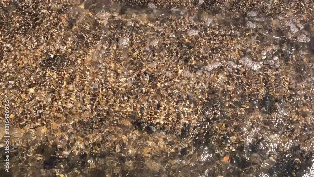 Sea water clear transparent with stones pebbles on the seabed. Natural background. Slow motion. Rocky shore. Glare ripple surface. Abstract textured natural backdrop. High quality 4k footage. Sea water clear transparent with stones pebbles on the seabed. Natural background. Slow motion. Rocky shore. Glare ripple surface. Abstract textured natural backdrop. High quality 4k footage.