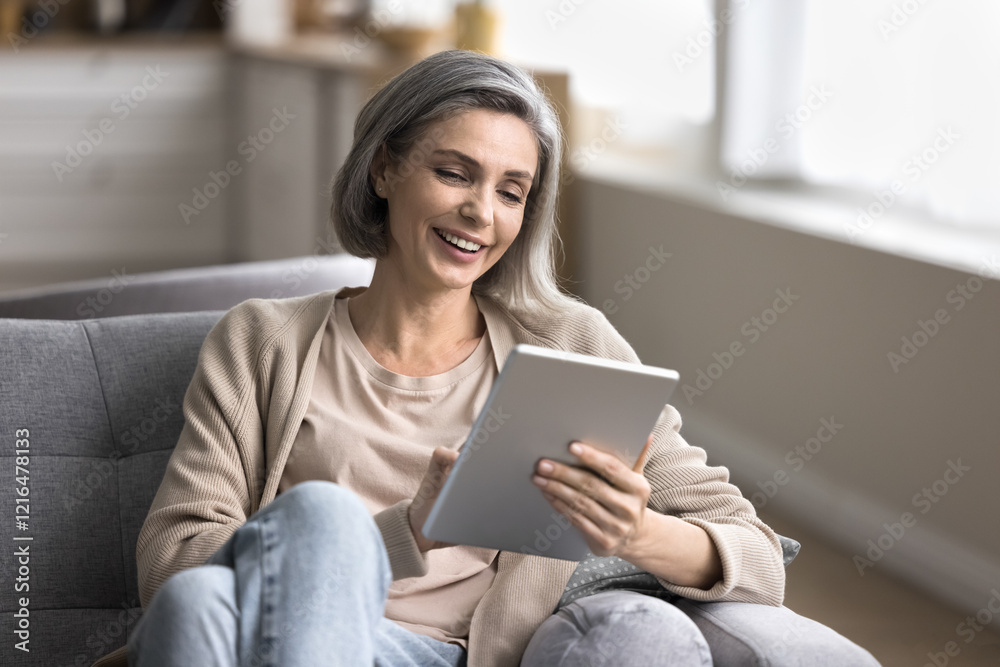 Socialization and networking. Portrait smiling middle aged woman rest on sofa at living room hold digital pad chat by video call engaged in online learning activity browse apps make internet payment Socialization and networking. Portrait smiling middle aged woman rest on sofa at living room hold digital pad chat by video call engaged in online learning activity browse apps make internet payment