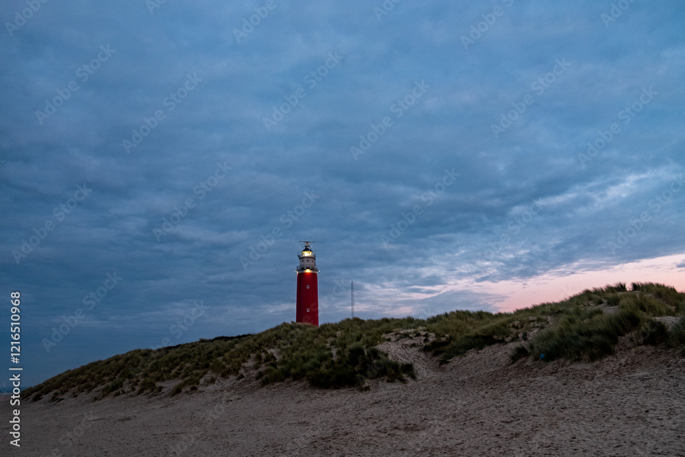 Eierland, De Cocksdorp, Texel, The Netherlands, Oktober 28th, 2024, A serene and tranquil lighthouse gracefully stands tall against a moody and dramatic sky during dusk on a sandy beach Eierland, De Cocksdorp, Texel, The Netherlands, Oktober 28th, 2024, A serene and tranquil lighthouse gracefully stands tall against a moody and dramatic sky during dusk on a sandy beach