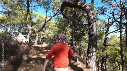 A man walks merrily through the forest at a fast pace. Dancing on the move