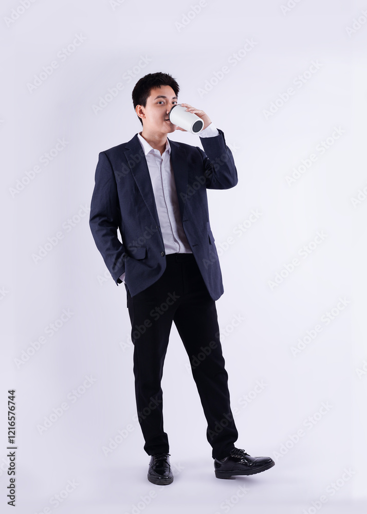 Full body image of a young Asian business man drink coffe and posing on a white background Full body image of a young Asian business man drink coffe and posing on a white background