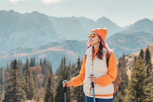 Obraz na płótnie Hiker with trekking poles admiring mountain landscape in autumn w salonie