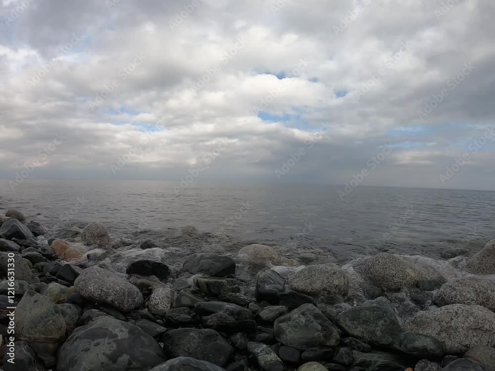 a peaceful scene with gorgeous scenes scattered along the coast, gentle waves meeting the stones, and a wonderful experience in the background