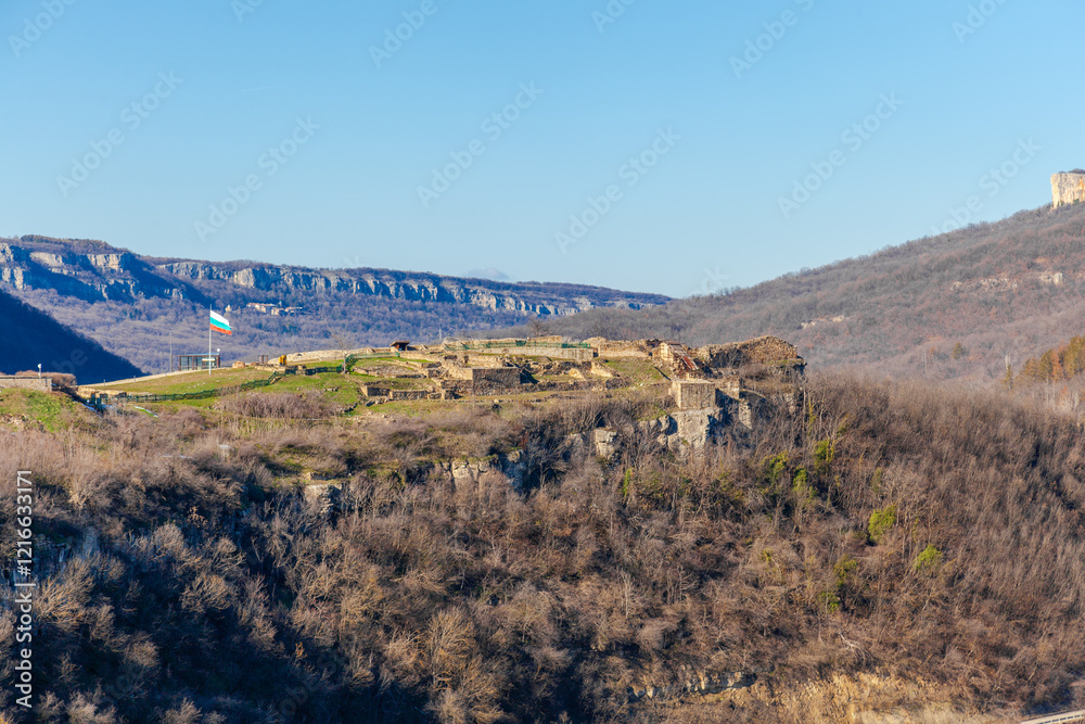 Tsarevets Fortress on a hill with a cloudy sky in the background