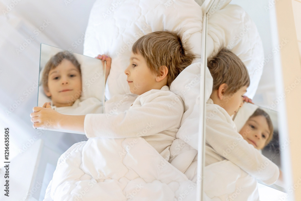 Portrait with mirrors of a child, lying in bed, reflection of his face