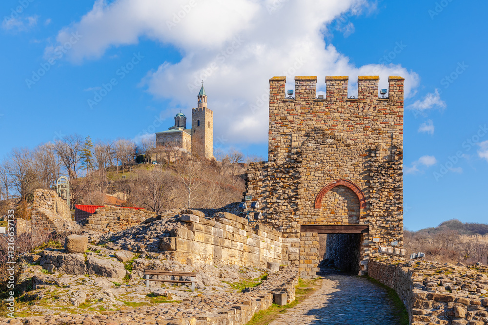 Tsarevets Fortress on a hill with a cloudy sky in the background