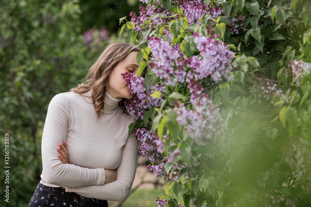 Spring blooming. Portrait of a pretty 30-year-old young woman in a blooming lilac garden in nature. Spring blooming. Portrait of a pretty 30-year-old young woman in a blooming lilac garden in nature.