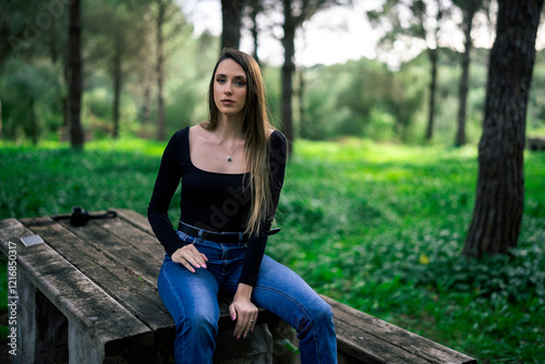 Obraz na płótnie Chica joven delgada vloggeando con cámara por zona verde con arboles w salonie