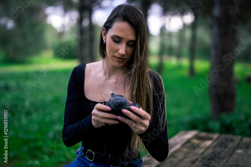 Obraz na płótnie Chica joven delgada vloggeando con cámara por zona verde con arboles w salonie