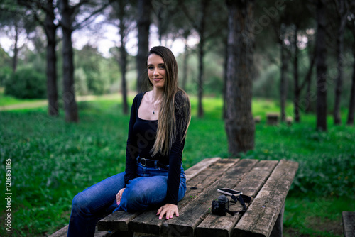Obraz na płótnie Chica joven delgada vloggeando con cámara por zona verde con arboles w salonie