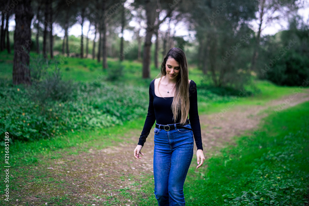 Chica joven delgada vloggeando con cámara por zona verde con arboles