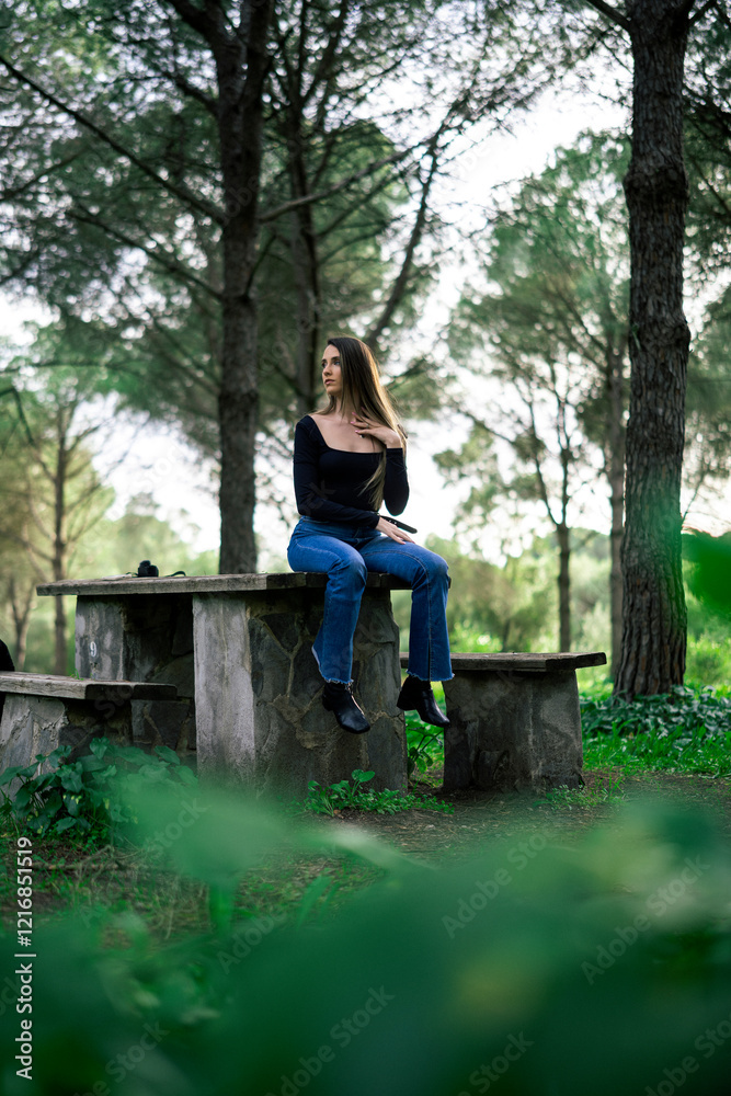 Chica joven delgada vloggeando con cámara por zona verde con arboles