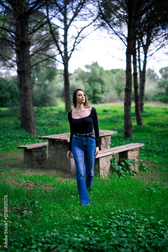 Obraz na płótnie Chica joven delgada vloggeando con cámara por zona verde con arboles w salonie