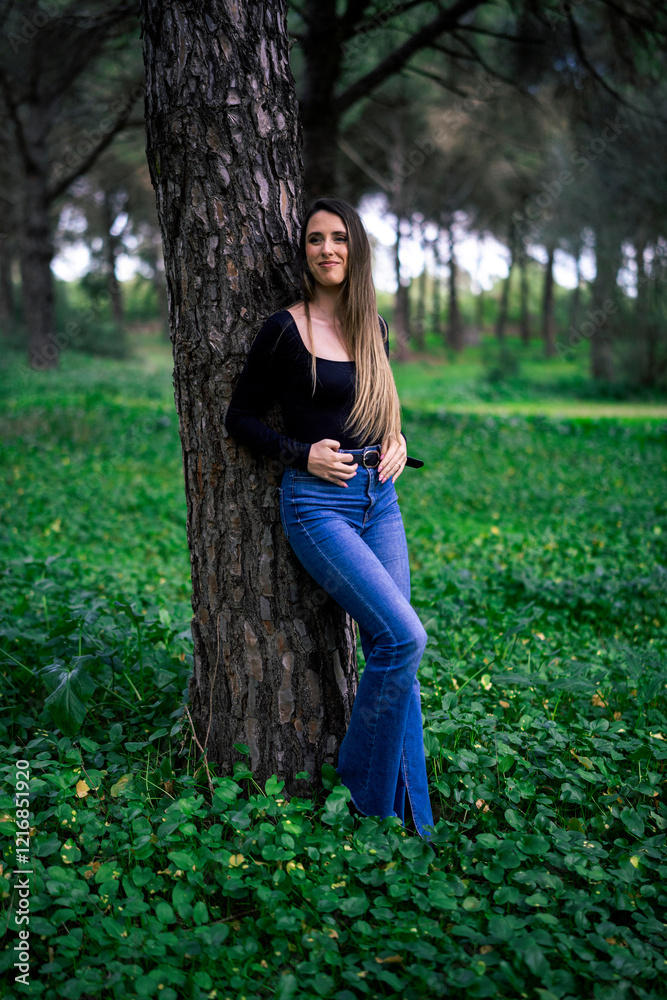 Chica joven delgada vloggeando con cámara por zona verde con arboles