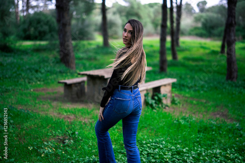 Obraz na płótnie Chica joven delgada vloggeando con cámara por zona verde con arboles w salonie