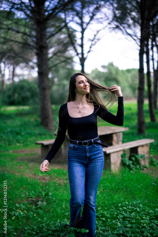 Chica joven delgada vloggeando con cámara por zona verde con arboles