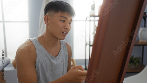 Young, attractive chinese man in a modern spa room examining something attentively indoors, showcasing a clean and relaxing wellness environment. Free Download Young, attractive chinese man in a modern spa room examining something attentively indoors, showcasing a clean and relaxing wellness environment. - GFXLoad