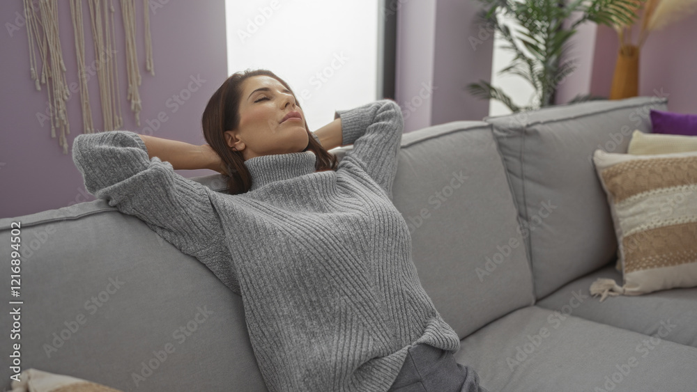 Woman relaxing on a comfortable couch in a cozy living room, wearing a grey sweater, brunette hair, enjoying peace, adult, beautiful, serene, home, apartment, indoor setting. Woman relaxing on a comfortable couch in a cozy living room, wearing a grey sweater, brunette hair, enjoying peace, adult, beautiful, serene, home, apartment, indoor setting.