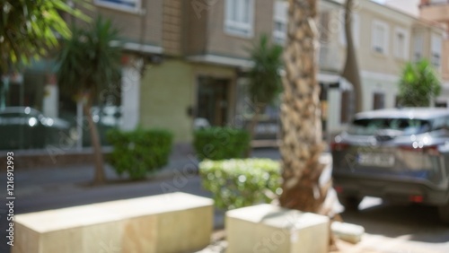 Blurred street scene with defocused cars, buildings, and trees on a sunny day photo